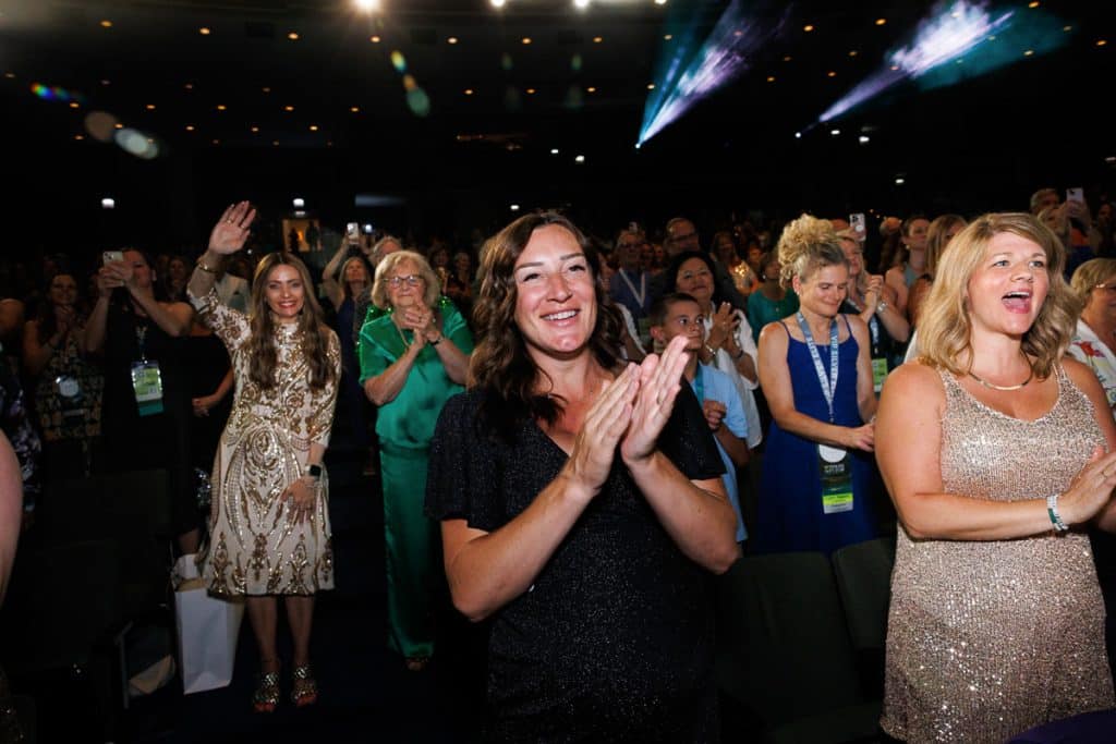 Corporate event audience clapping and smiling during an awards ceremony, captured by Chicago corporate event photographer.