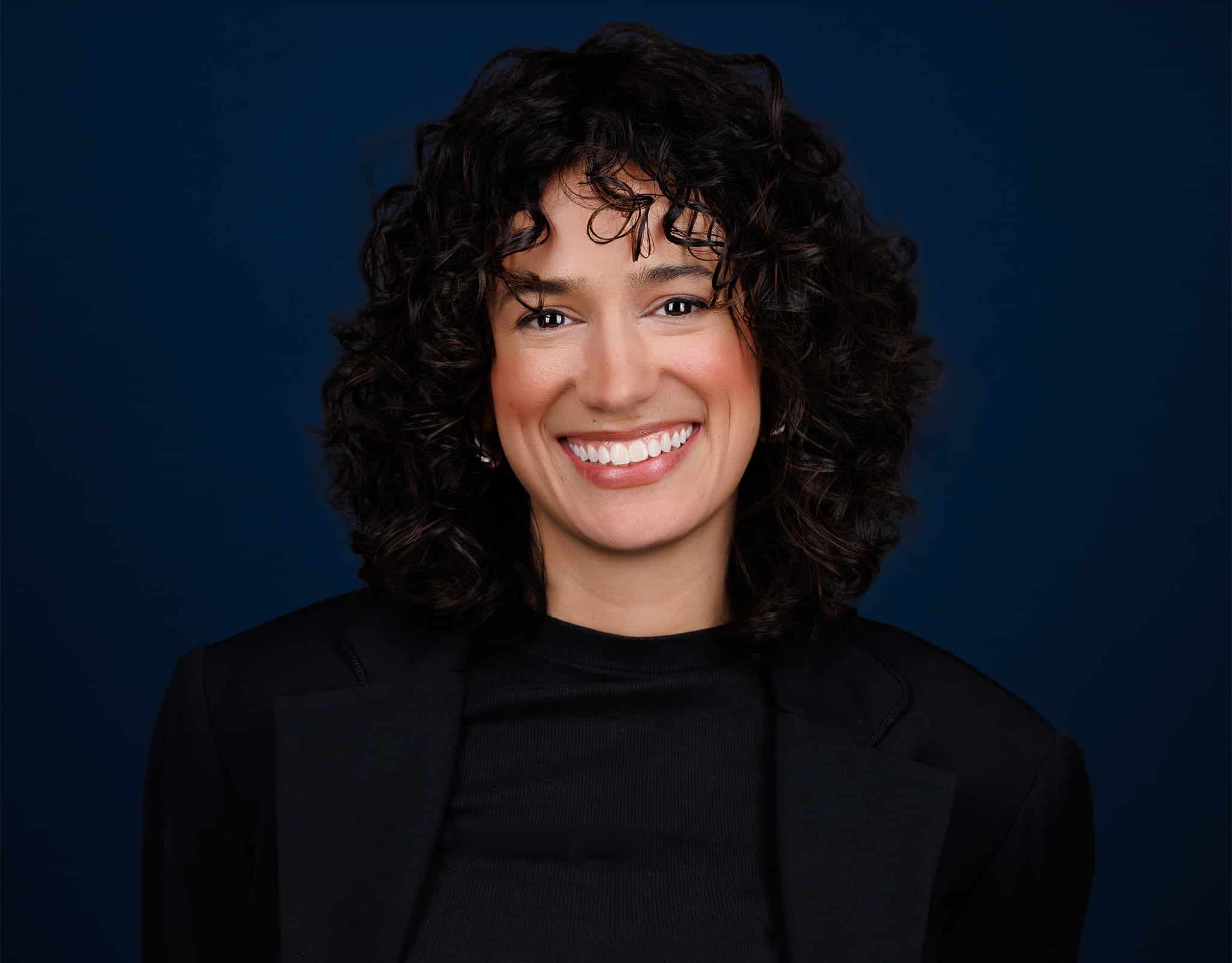 Confident corporate headshot captured at a Chicago Headshot Lounge with deep blue background.