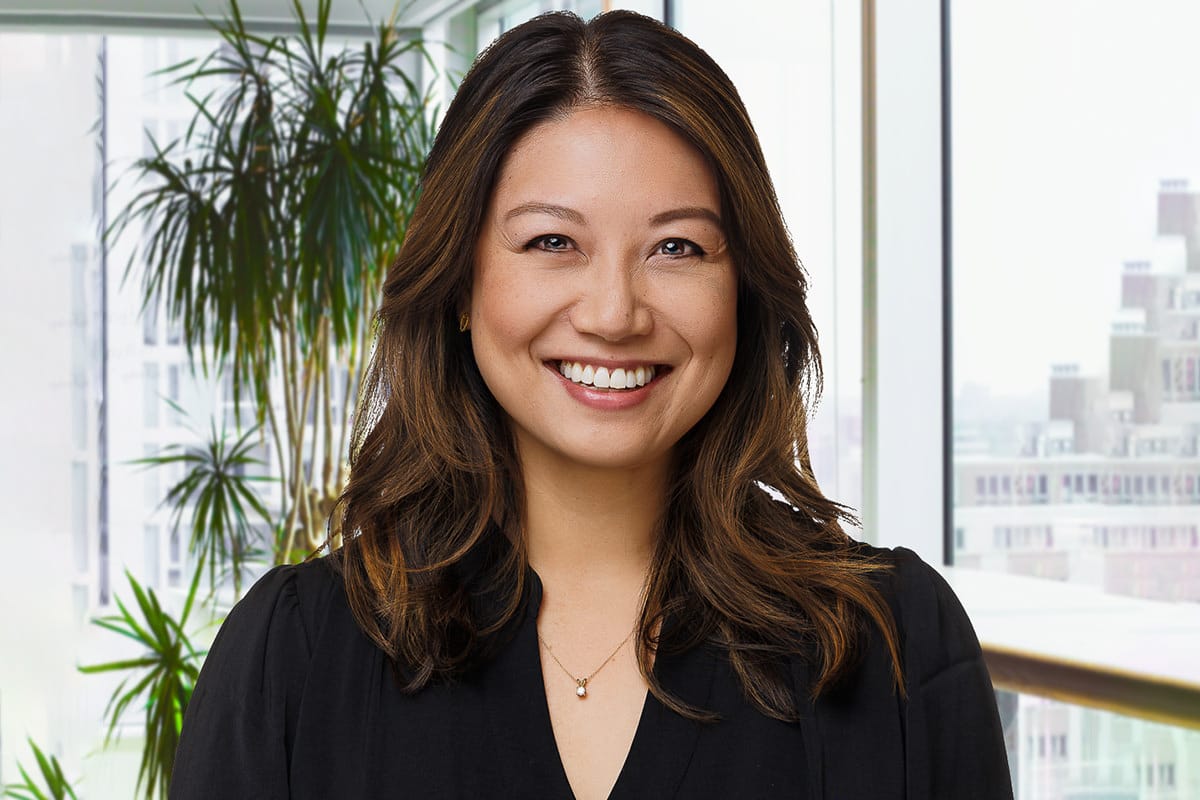 Chicago corporate headshots – professional environmental portrait of a smiling woman in a modern office setting.