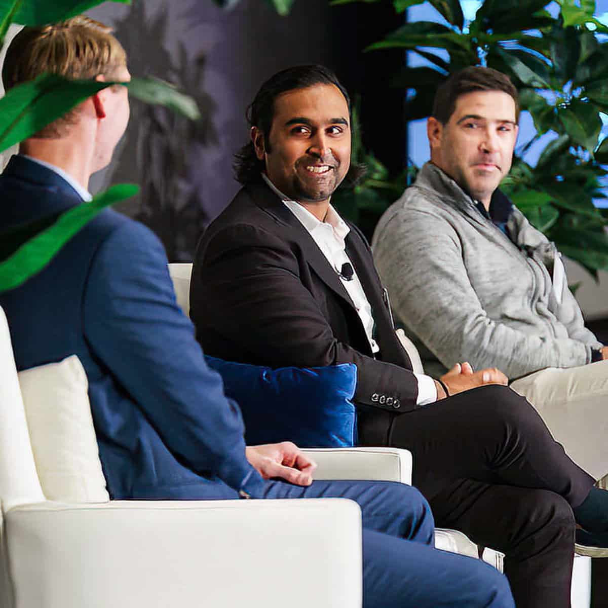Three men seated on stage during a corporate panel discussion in Chicago