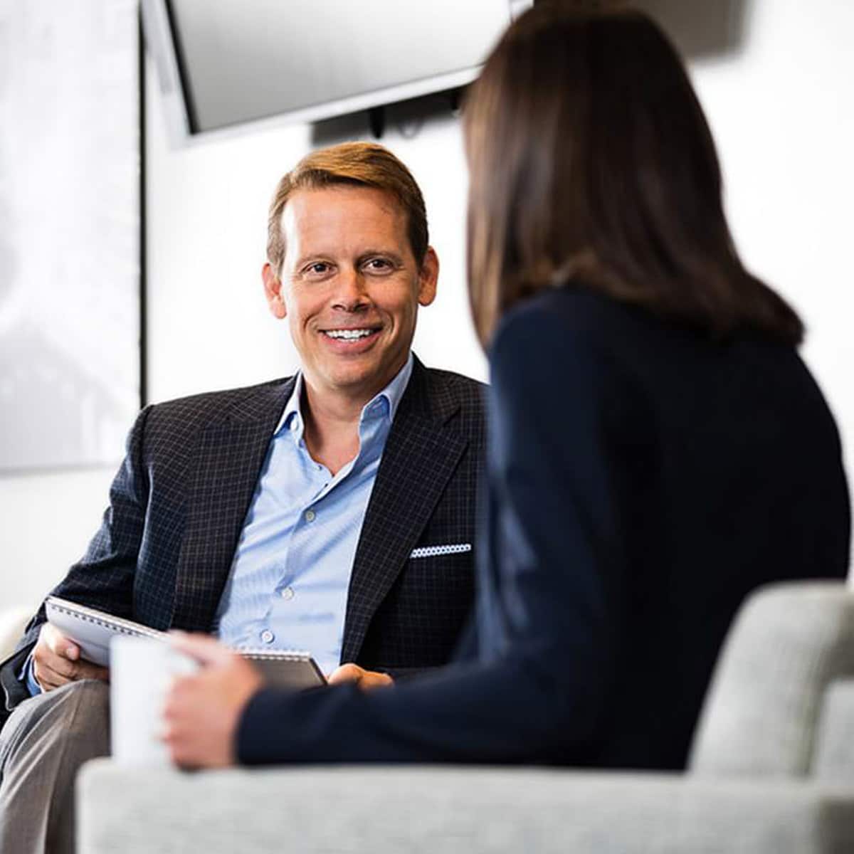 Chicago business photographer captures a candid conversation between two professionals in a modern office setting