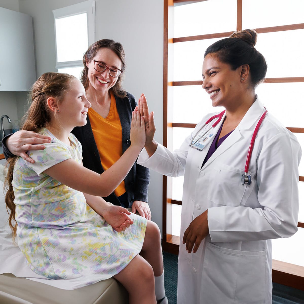 Chicago business photographer captures a healthcare professional high-fiving a young patient during a clinic visit