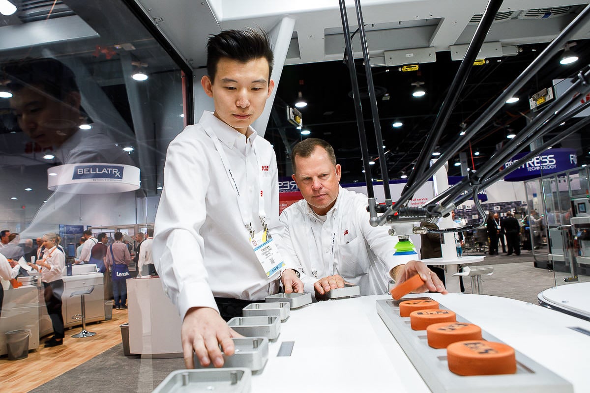 Exhibitors demonstrating products at a trade show booth in Chicago, photographed by Chicago corporate event photographer Tori Soper.