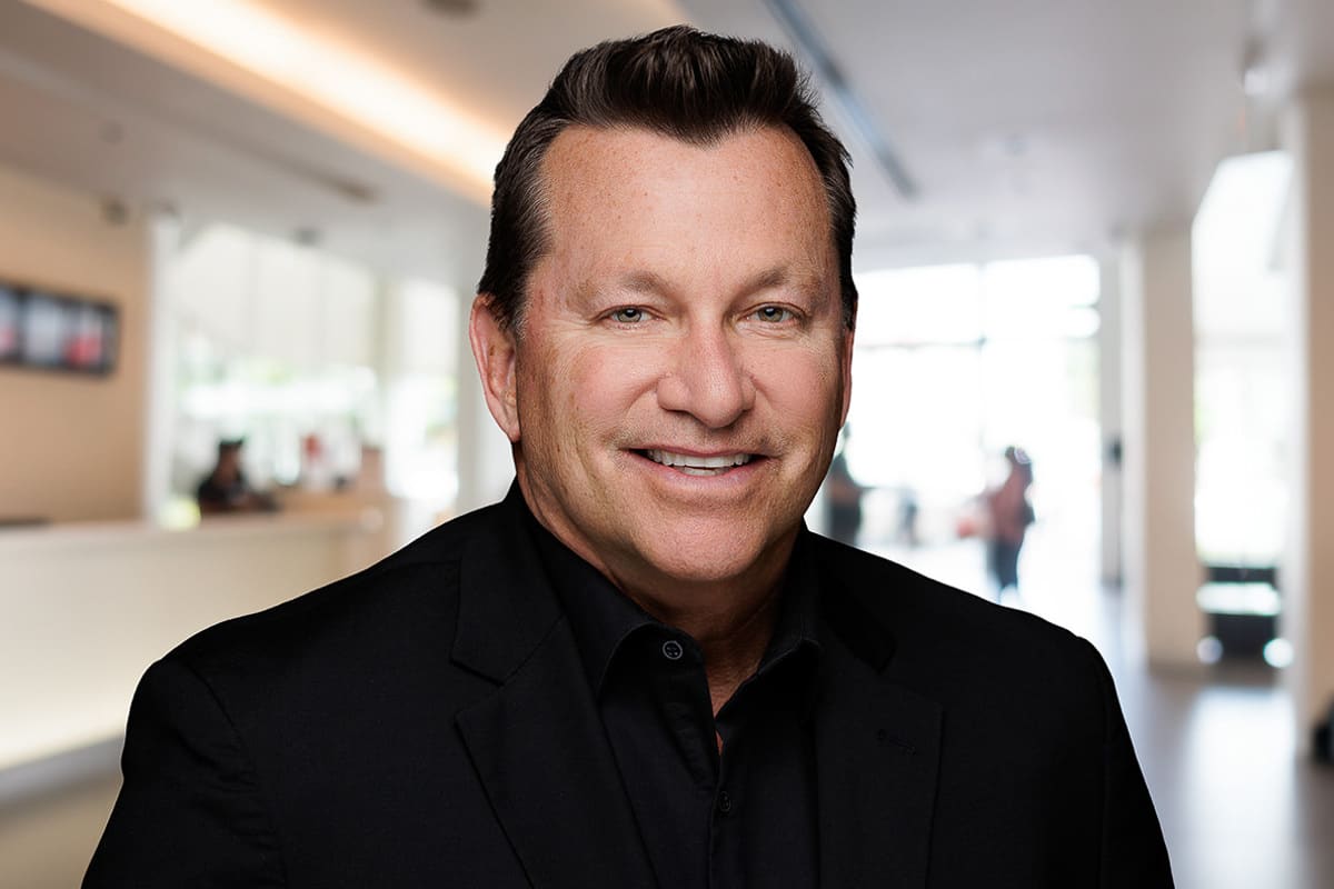 Friendly man in a black shirt, photographed in a bright office space, Chicago corporate headshot.