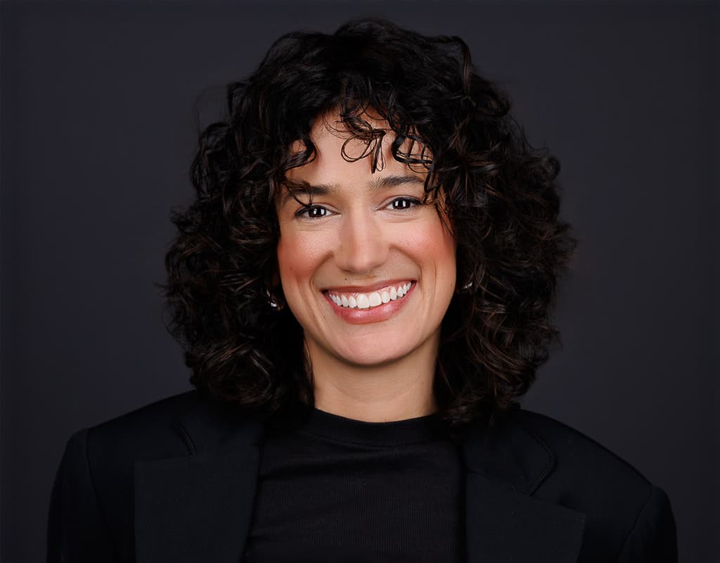 Smiling professional in a dark blazer posing for a corporate headshot session