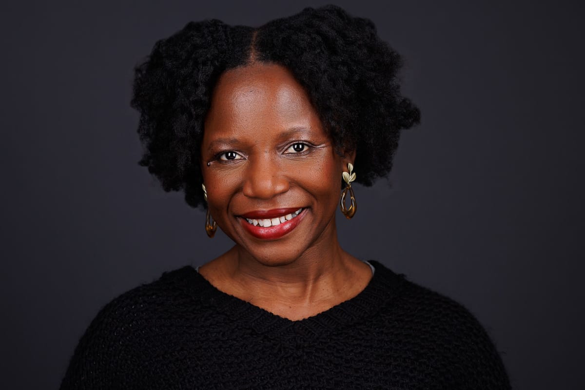 Business executive woman with natural hair, smiling, Chicago corporate headshot by Tori Soper Photography.